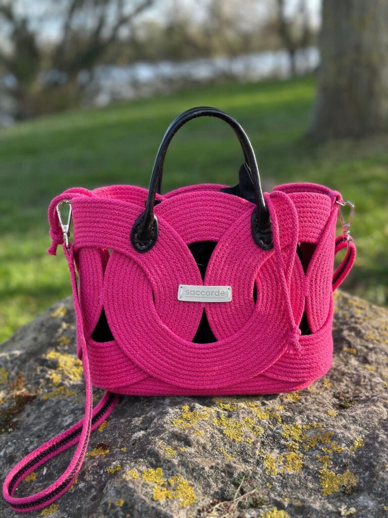 Sac Aura Fuschia sur une pierre devant un Lac à Amiens